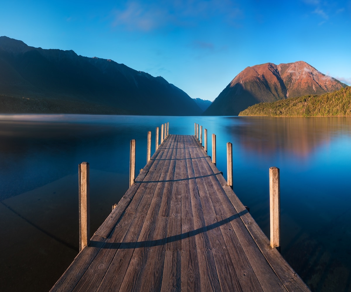 Romantic wharf on Lake Rotoiti, view ovelooking misty Saint Arnaud Ridge, all part of Nelson Lakes National Park in north od South Island of New Zealand Beautiful pier on sunrise